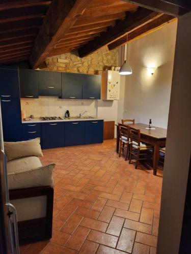 een keuken met blauwe kasten en een tafel met stoelen bij Casa Fiore in Passignano sul Trasimeno