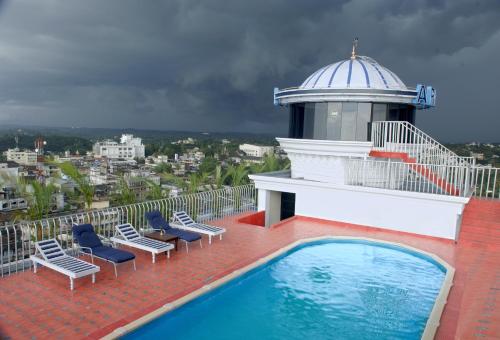 un balcón con sillas y una piscina en un edificio en Hotel Arcadia, en Kottayam