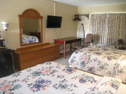 a bedroom with two beds and a dresser and a mirror at Relax Inn in Rome