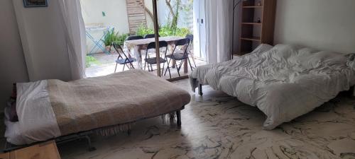 a bedroom with a bed and a table and chairs at Calme et Plages in Menton
