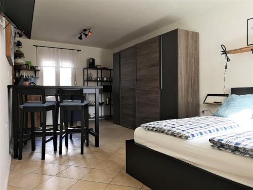 a bedroom with a bed and a kitchen with a table at Apartmaji Prton Bovec in Bovec
