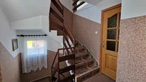 a staircase in a house with a wooden door at Róża Wiatrów 2 Władysławowo in Władysławowo