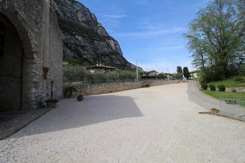 een weg naast een stenen muur met een berg bij Agriturismo Antico Fenilon in Brentino Belluno
