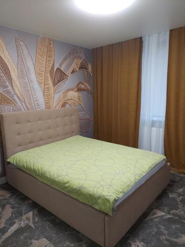 1 dormitorio con 1 cama con colcha verde en Сучасні апартаменти Палац Спорту, en Járkov
