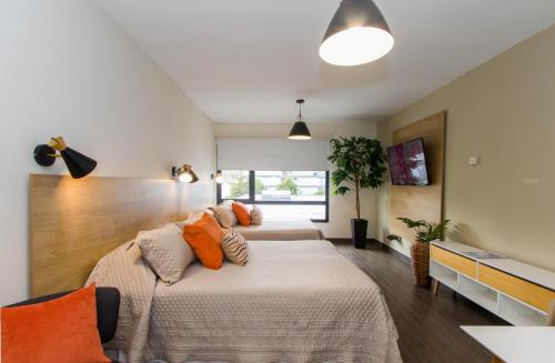 een slaapkamer met een bed met oranje kussens bij Rivadavia Apartamentos in Ushuaia