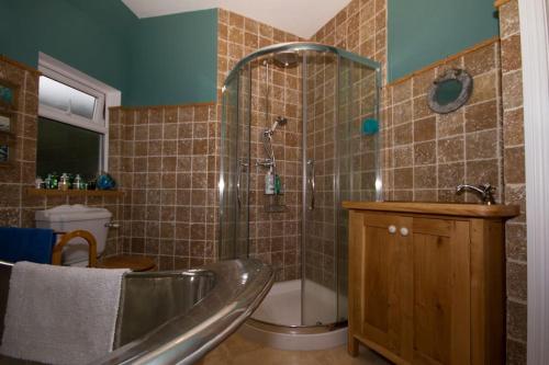a bathroom with a tub and a shower and a toilet at Spacious 4-Bed House in Lynton in Lynton