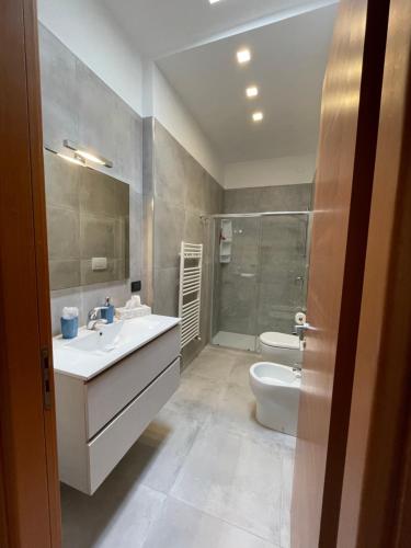 uma casa de banho com um lavatório, um WC e um chuveiro em appartamento vista mare da MARY em Gallipoli