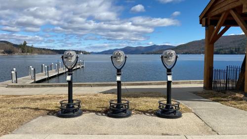 a row of parking meters in front of a body of water at Depe Dene Lakeside Resort in Lake George