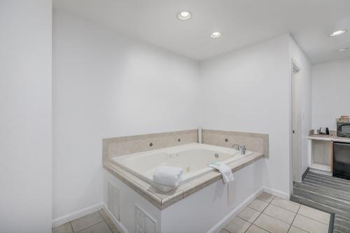 a white bathroom with a tub in a room at Crossroads Inn & Suites in Gatlinburg