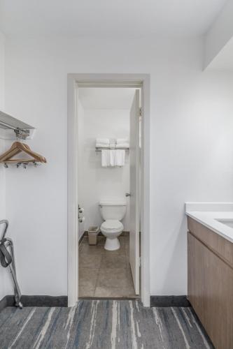 a white bathroom with a toilet and a sink at Crossroads Inn & Suites in Gatlinburg