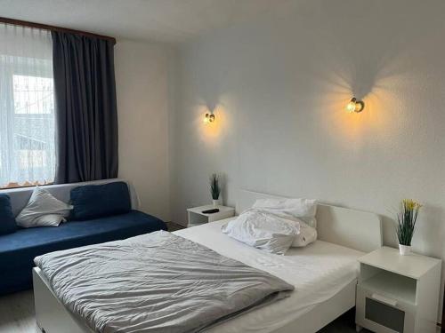 1 dormitorio con 1 cama y 1 sofá azul en Vacation home for up to 6 guests 