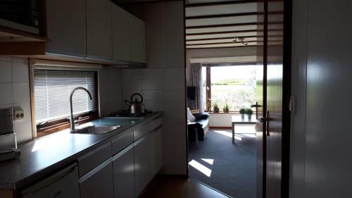eine Küche mit einem Waschbecken und einem großen Fenster in der Unterkunft Stacaravanverhuur Kroon chalet B-10 in Workum