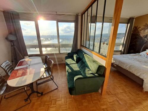 Cette chambre comprend un lit, une table et un canapé. dans l'établissement Sous les Etoiles - dans le plus haut gratte-ciel avec parking, à Rouen