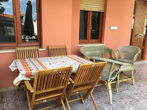 カーラゴノネにあるappartamento Oleandroの木製テーブルと椅子付きのパティオ