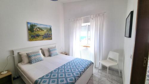 a white bedroom with a bed and a window at SALEMA - Amazing View Apartment in Salema