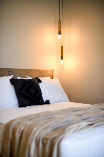 a bed with a black pillow sitting on top of it at Ambient Living Lofts in Preveza