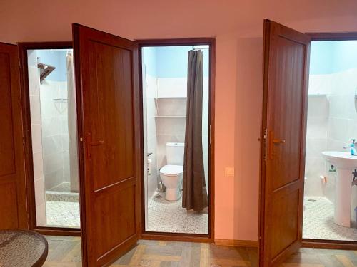 a bathroom with two doors and a toilet and a sink at Hostel 47 in Batumi