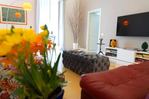 een woonkamer met een bank en een tv en bloemen bij Cassari 61 in Palermo