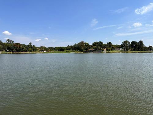 a large body of water with trees in the background at Pousada Rancho na Represa in Nova Odessa
