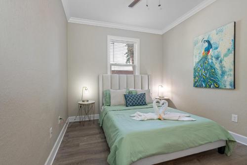 a bedroom with a green bed with a painting on the wall at Cozy and spacious 4BR House with pool in TAMPA in Tampa