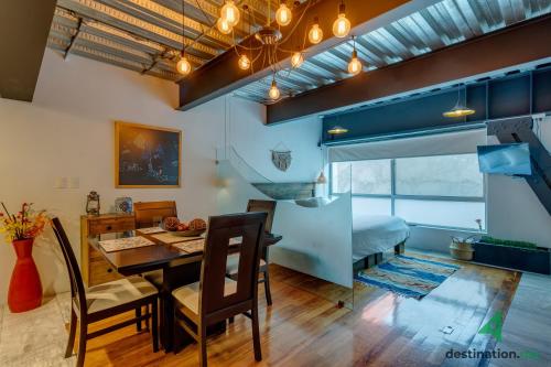 - une salle à manger et un salon avec une table et des chaises dans l'établissement Cozy & Vibrant Loft with Rooftop & Gym in Polanco, à Mexico