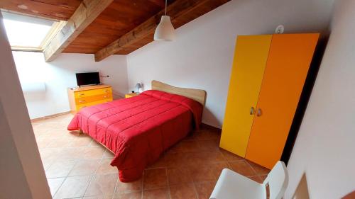 um quarto com uma cama vermelha e um armário amarelo em b&b Don Peppe - Don Ilario em San Mauro Cilento