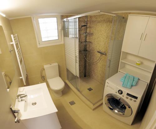 a bathroom with a shower and a washing machine at Cozy corner Schinias beach house in Schinias