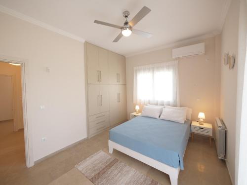 a bedroom with a blue bed and a window at Cozy corner Schinias beach house in Schinias