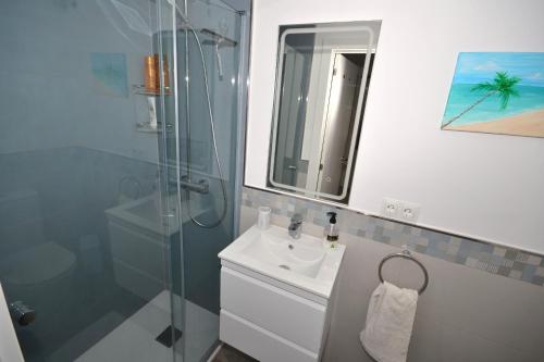 ein Bad mit einem Waschbecken und einer Glasdusche in der Unterkunft Bahia azul in Estepona