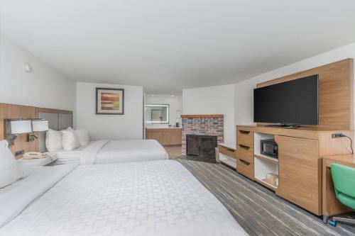 a hotel room with two beds and a flat screen tv at Crossroads Inn & Suites in Gatlinburg