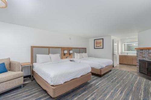 a hotel room with two beds and a couch at Crossroads Inn & Suites in Gatlinburg
