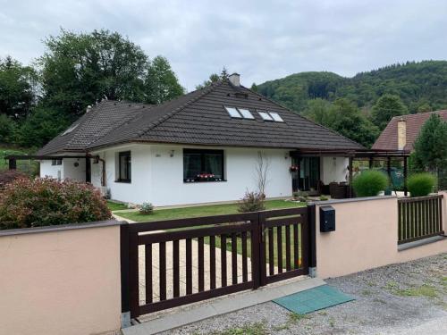 a small white house with a wooden fence at Bystra 150 in Bystrá