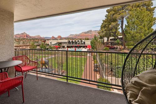 a balcony with red chairs and a view of the mountains at Arabella Hotel Sedona in Sedona