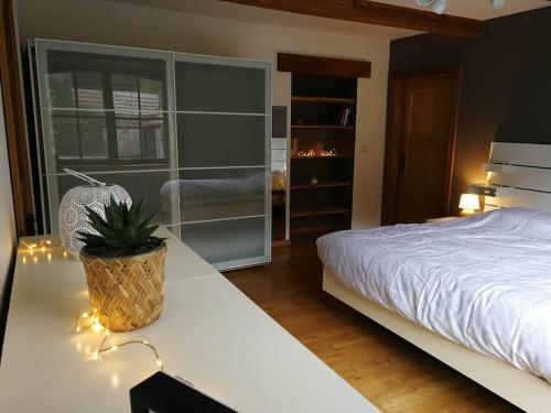 Un dormitorio con una cama y una mesa con una planta. en La sittelle des aguesses, en Andenne