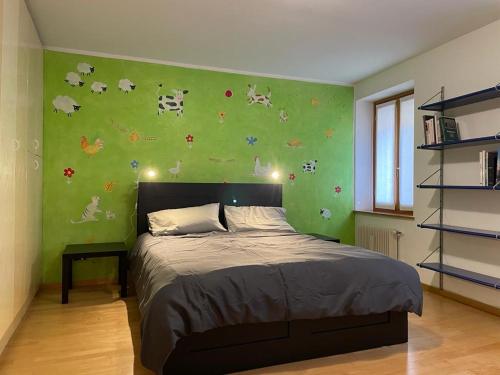 een slaapkamer met een bed met een groene muur bij Cortazzis 6 in Udine
