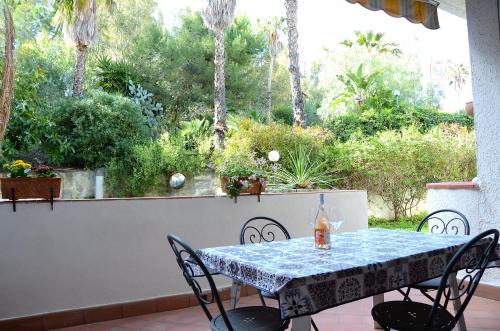 - une table et des chaises sur une terrasse avec vue sur le jardin dans l'établissement Sea Breeze Acitrezza, à Aci Castello