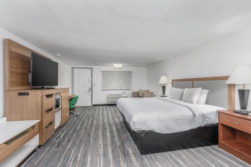 a hotel room with a large bed and a flat screen tv at Crossroads Inn & Suites in Gatlinburg