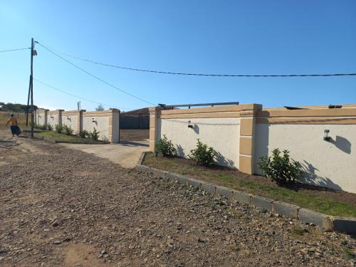 a row of buildings on the side of a dirt road at Sweetwaters Guest House in Estcourt