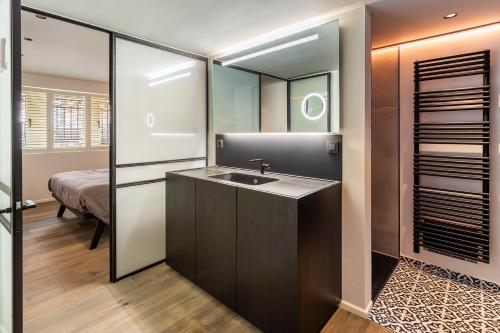 ein Bad mit einem Waschbecken und einem Spiegel in der Unterkunft luxe en authenticiteit in Antwerpen