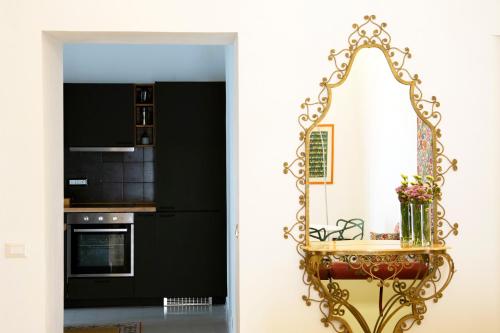 een keuken met zwarte en witte muren en een gouden spiegel bij Cassari 61 in Palermo