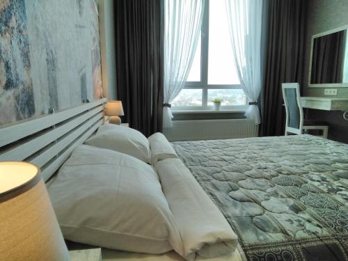 a bedroom with a large bed with pillows and a window at Panorama Lviv in Lviv