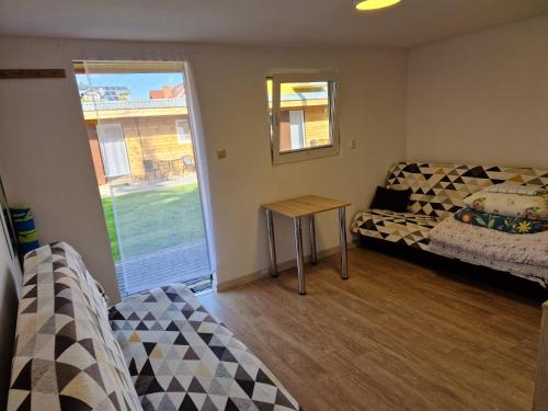 een kamer met een bed, een tafel en een raam bij Kwatery u Beaty in Krynica Morska - Piaski
