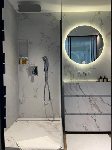 a bathroom with a shower with a round mirror at Parc Montfleury in Cannes