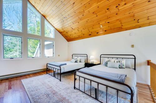 1 dormitorio con 2 camas y techo de madera en Lake George Oasis with 9 Acres, Hot Tub and Game Room!, en Diamond Point