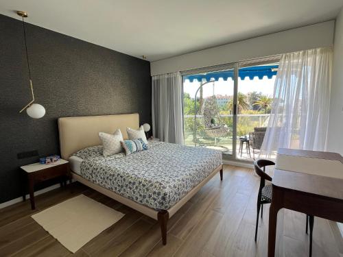 a bedroom with a bed and a large window at Parc Montfleury in Cannes