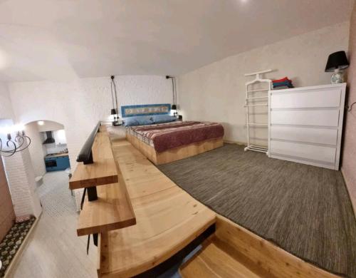 1 dormitorio con cama y escritorio de madera en Plexanovi Apart, en Tiflis
