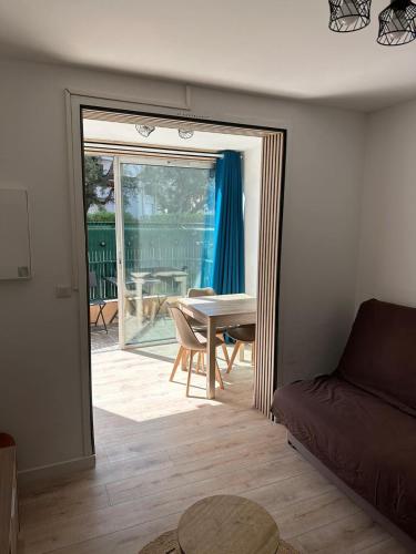 d'un salon avec une table et une porte coulissante en verre. dans l'établissement Charmant studio neuf 150m plage sur avenue principale climatisé et parking, à Cavalaire-sur-Mer