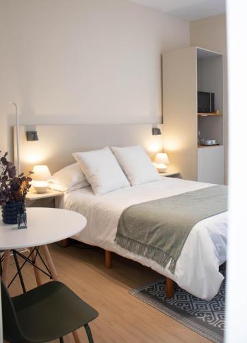 a bedroom with a large bed and a table at Apartamentos Concepcion Centro in Albacete