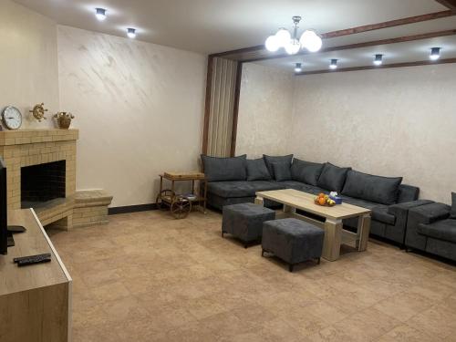 un soggiorno con divano e tavolo di Tsaghkadzor Villa a Tsaghkadzor