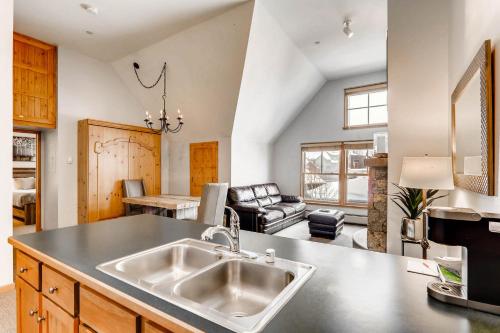 a kitchen with a sink and a living room at Jackpine & Black Bear Condominiums by Keystone Resort in Keystone